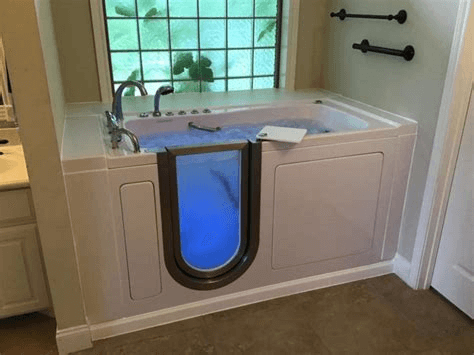 A walk in tub with a door in a bathroom.