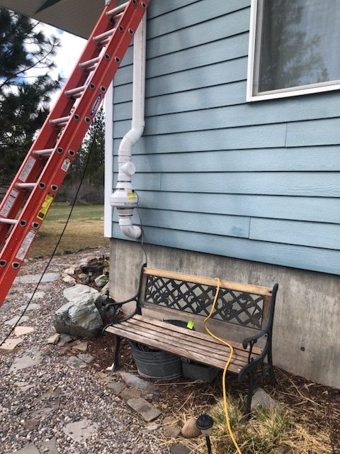 A Ladder is Attached to the Side of a House Next to a Bench