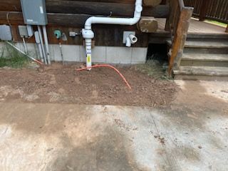 A Hose is Connected to a Pipe on the Side of a House