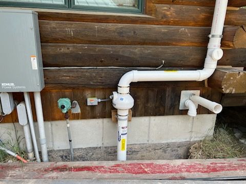 A White Pipe is Attached to the Side of a Wooden Building