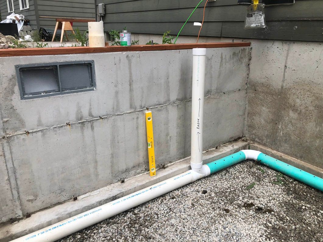 A Bunch of Pipes Are Sitting on the Ground Next to a Wall