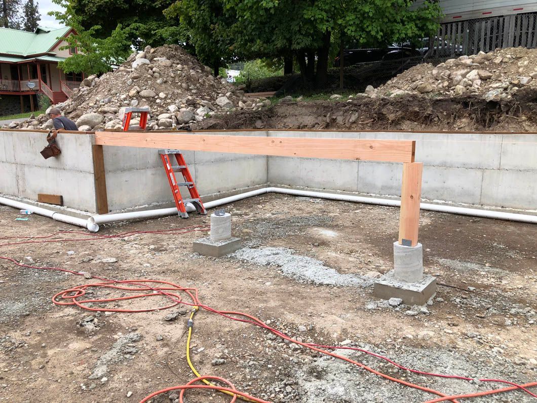 A Wooden Post is Sitting in the Middle of a Dirt Field Next to a Ladder