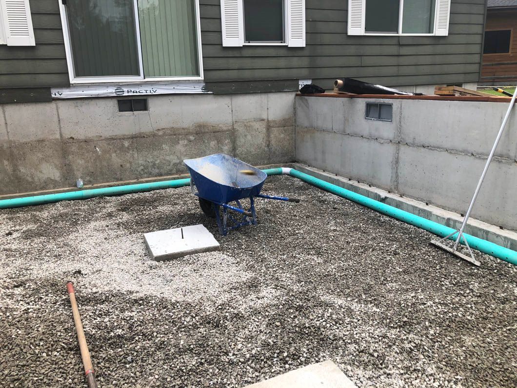 A Wheelbarrow is Sitting in the Dirt in Front of a House