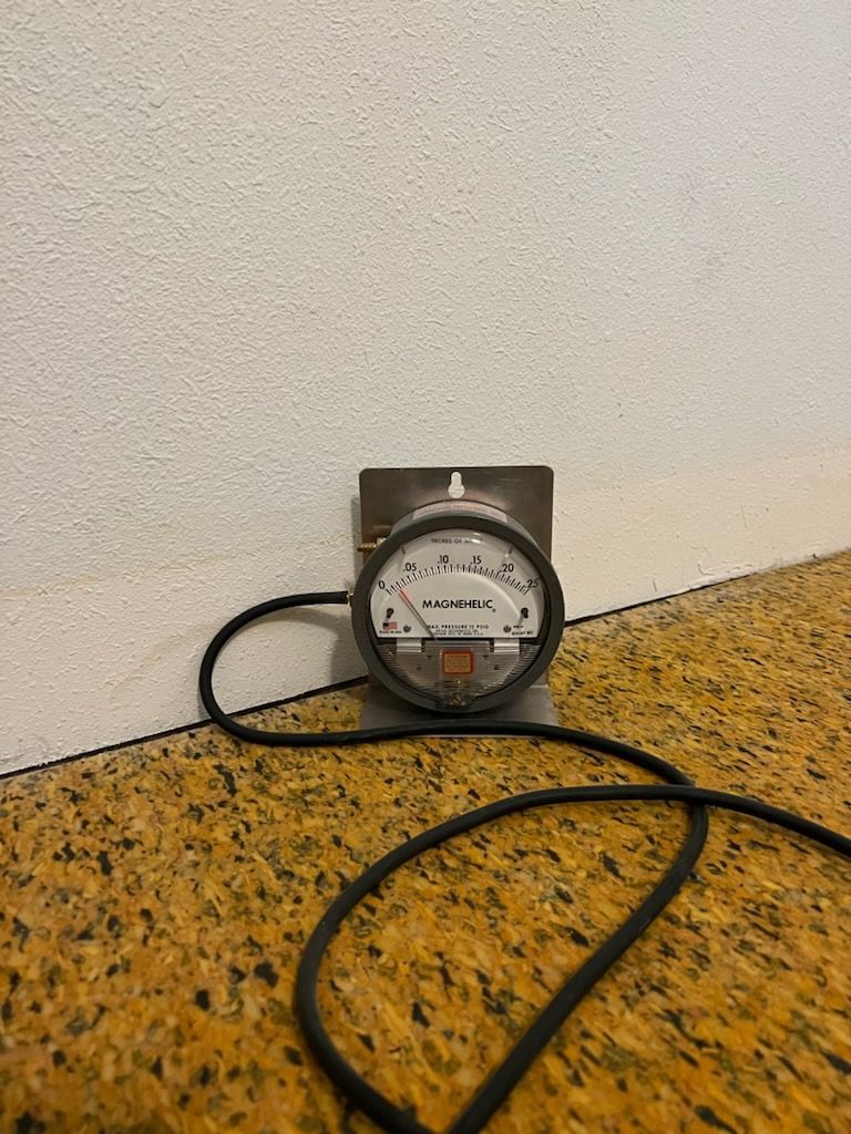 A Gauge is Sitting on a Yellow Carpet Next to a Wall