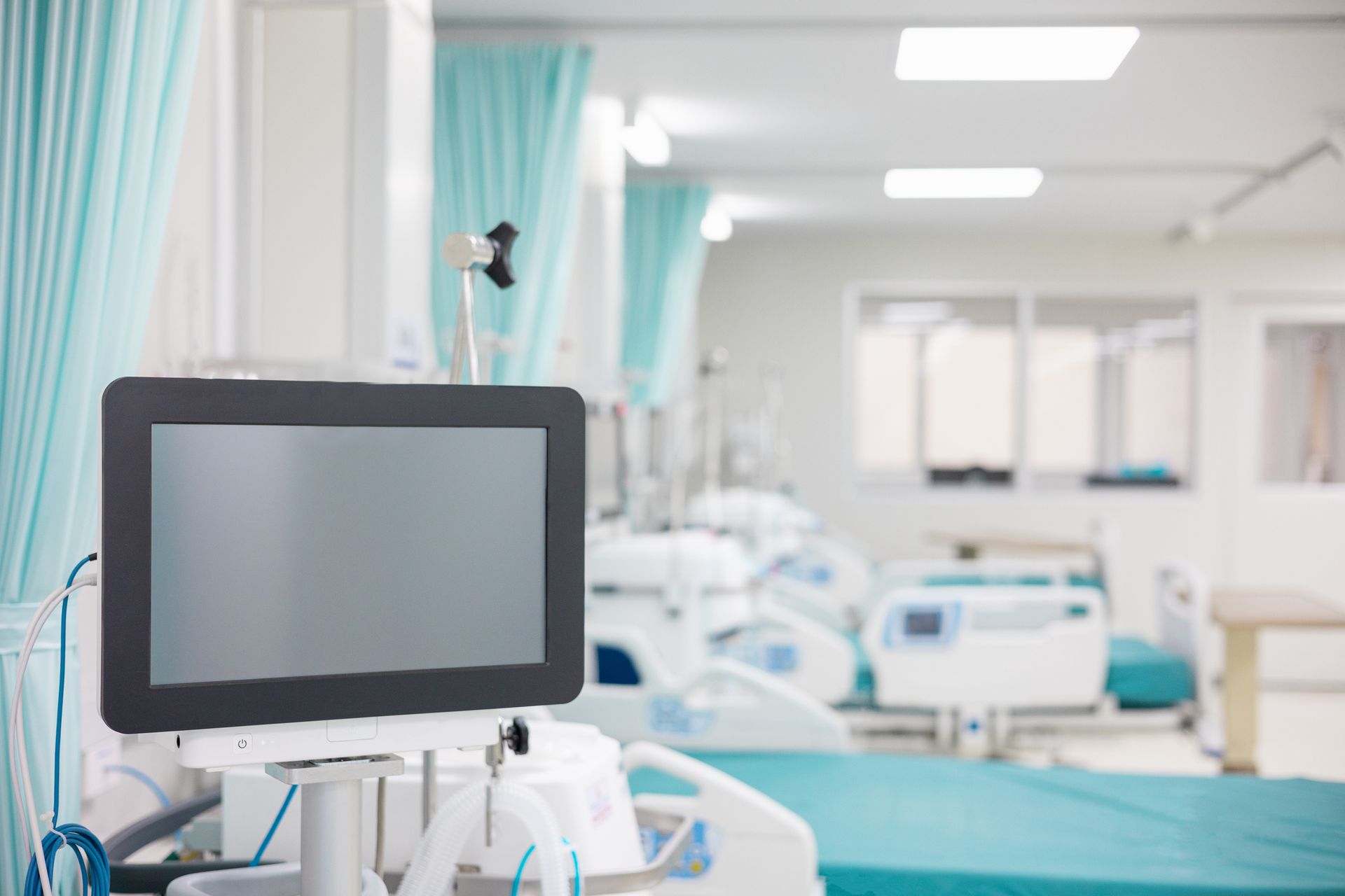 A hospital room with beds and a monitor in the foreground - Houston, TX - Ramsey & Company Manufacturer’s Representatives
