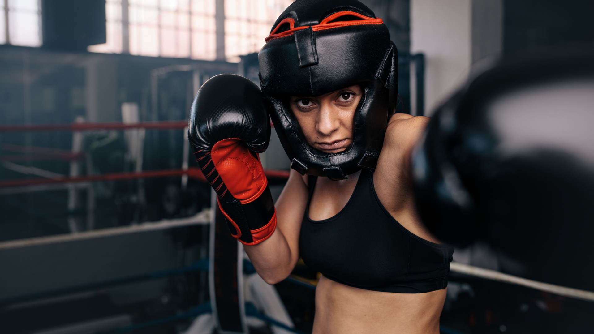 Two men are boxing in a gym.