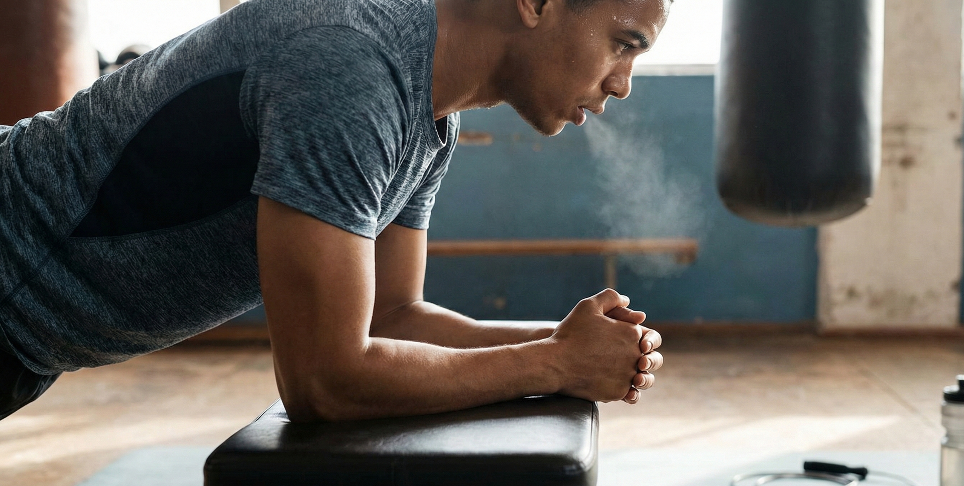Gym interior with equipment: rolled mat, boxing gloves, medicine ball, punching bag, cityscape backdrop.