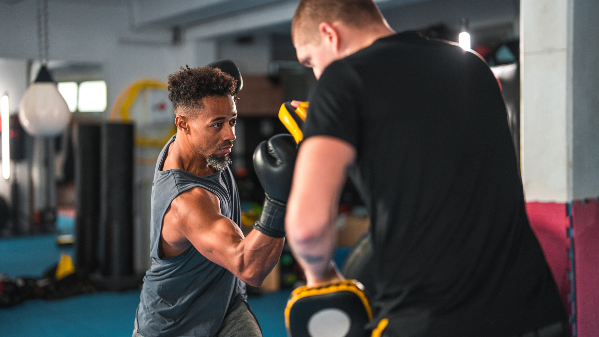 Two men are boxing in a gym.