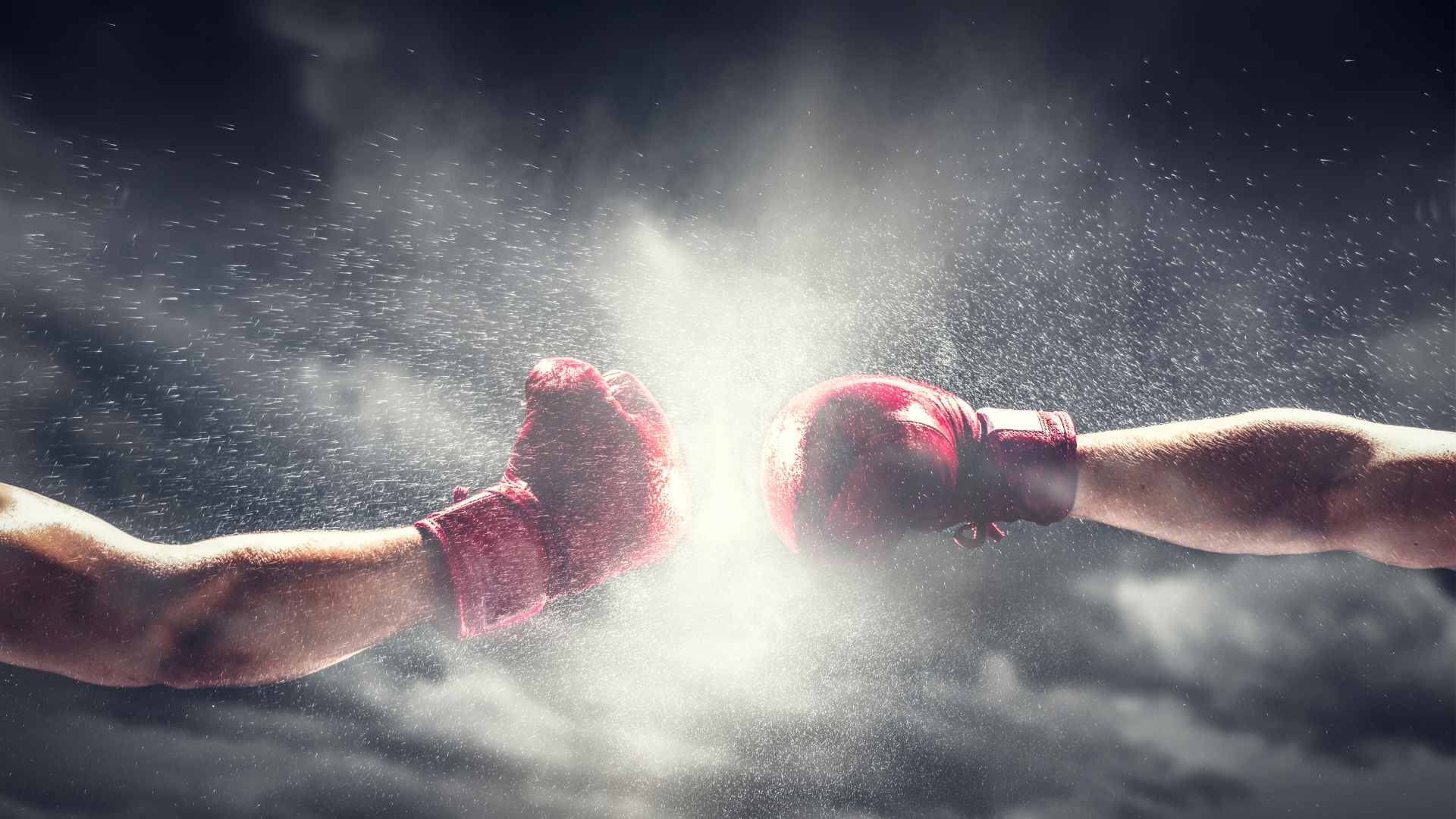 Two boxing gloves are being thrown at each other.