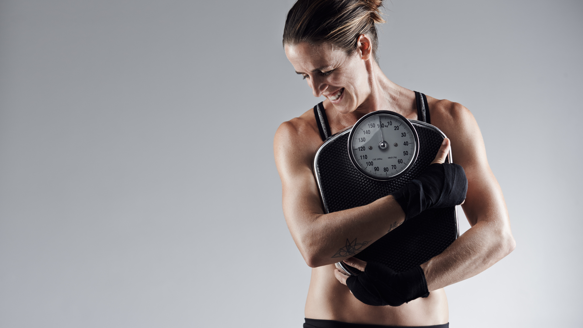 A woman is holding a scale in her hands.