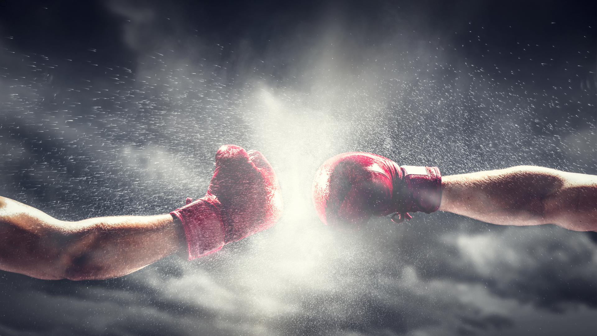 Two boxers are fighting each other with their hands in the air.