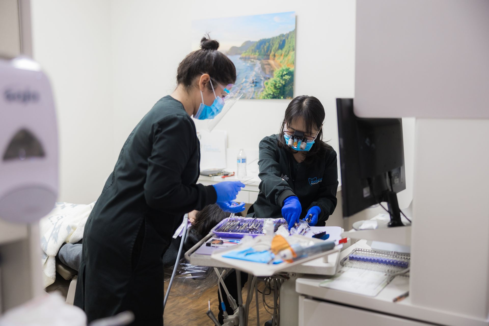A woman is sitting in a dental chair getting her teeth examined by a dentist.