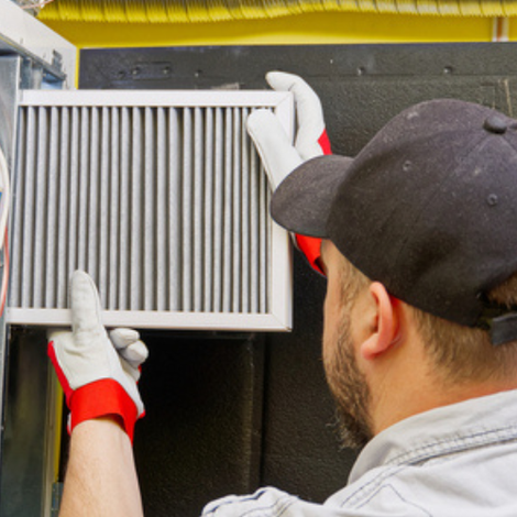 A man wearing a hat and gloves is holding a filter.