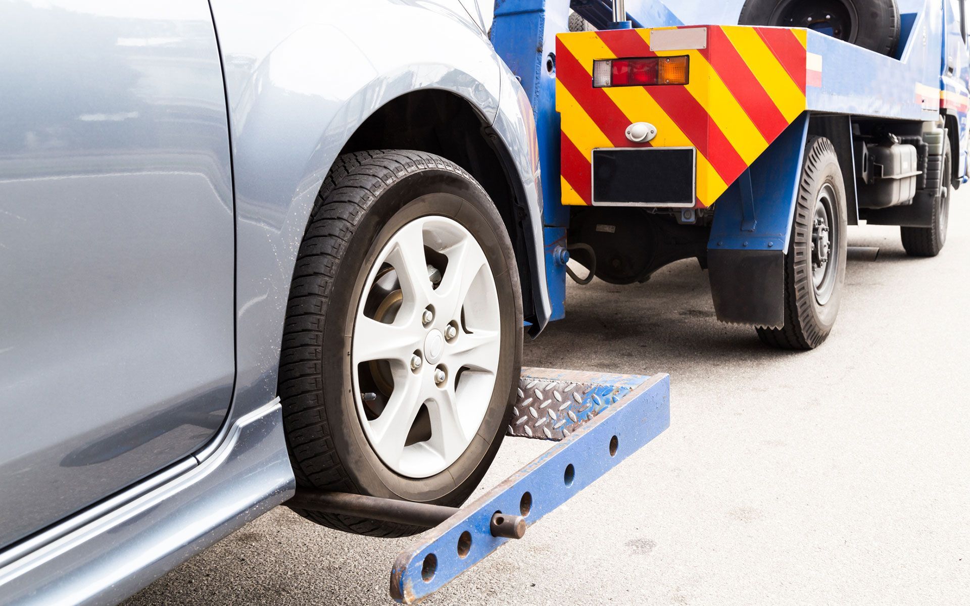 A car is being towed by a tow truck.