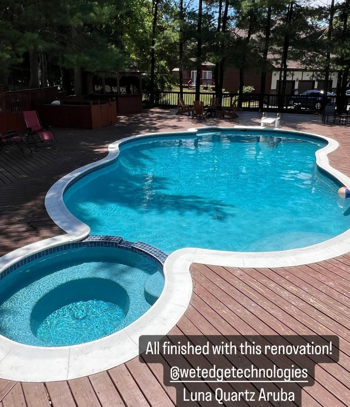 A large swimming pool with a hot tub next to it