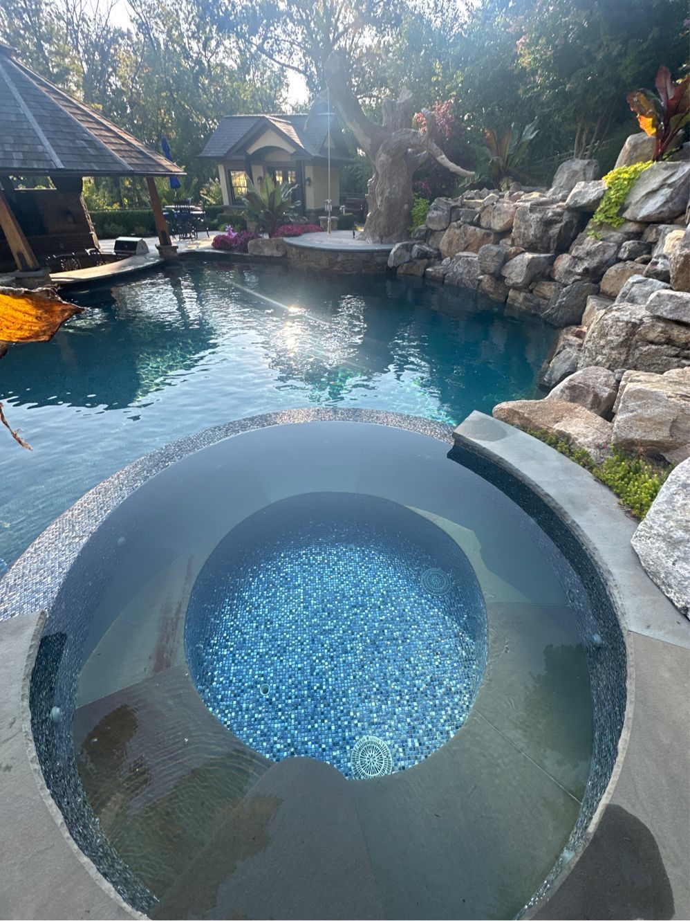 A large swimming pool with a hot tub in the middle of it.