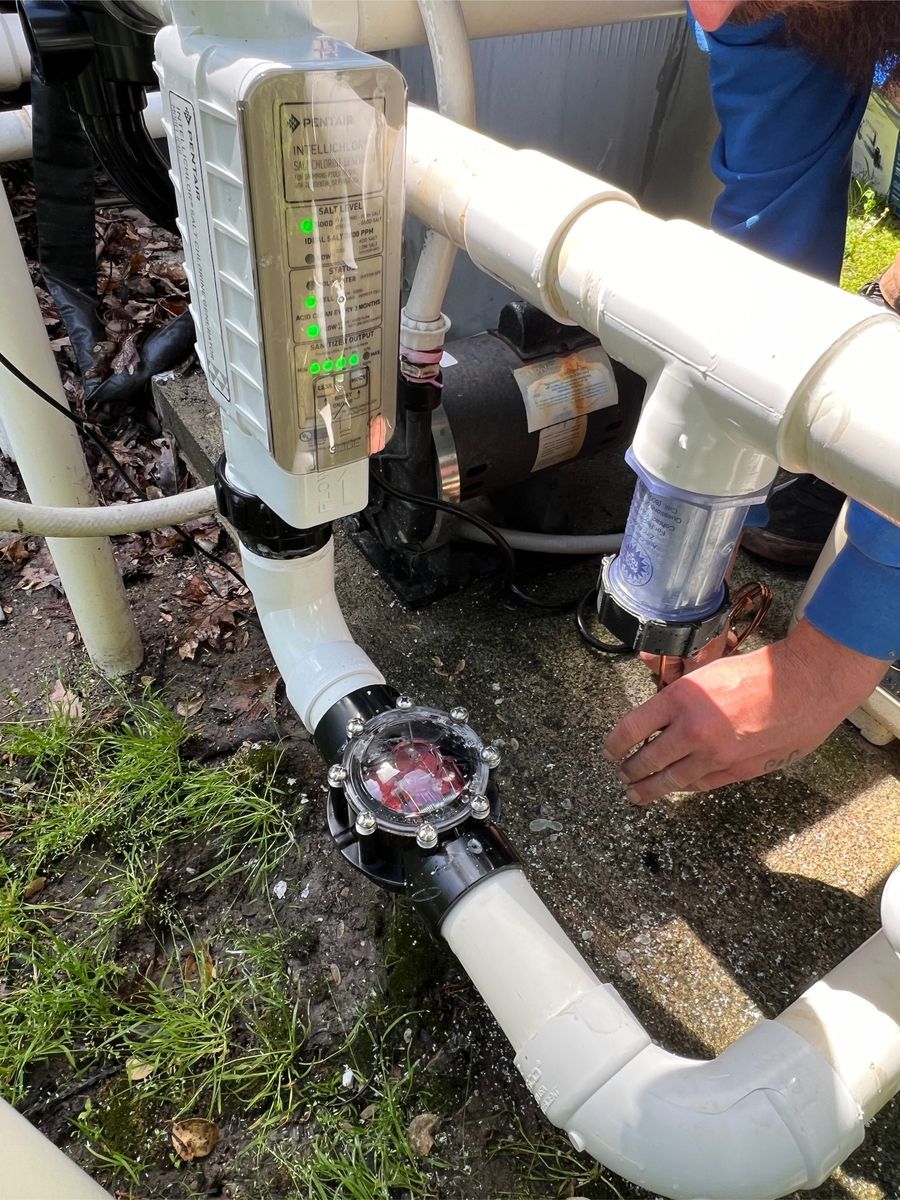 A person is working on a pipe with a thermometer attached to it.