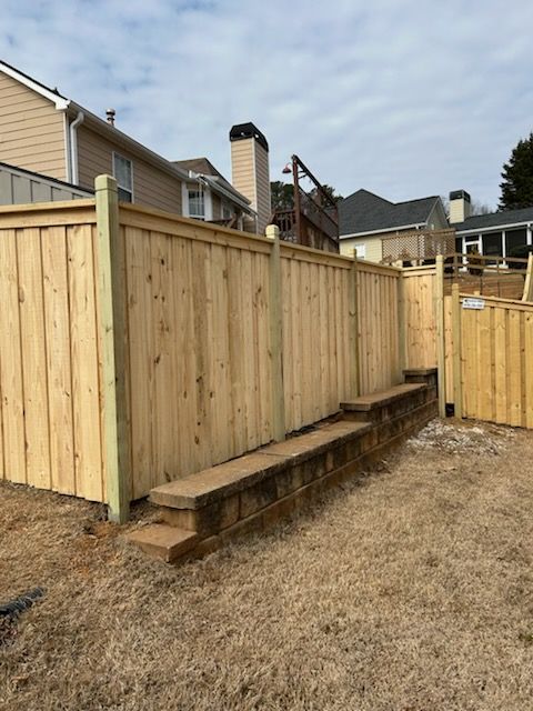 A wooden fence with a house in the background.
