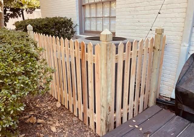 A wooden fence with a house in the background.