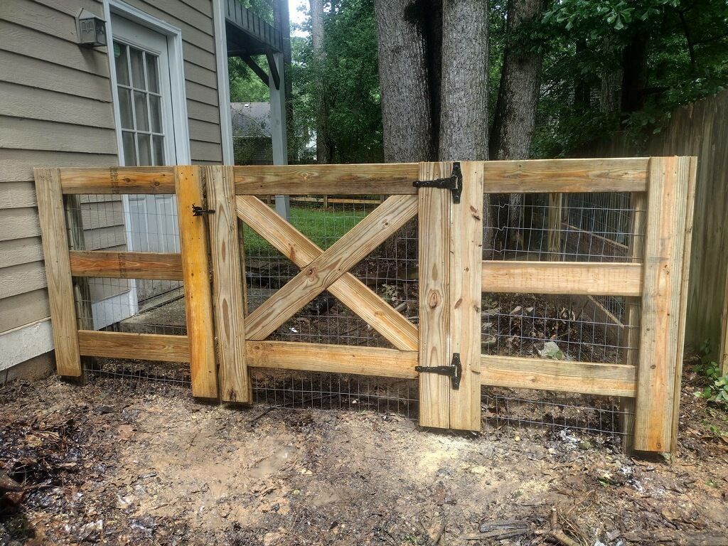 A wooden gate is sitting in front of a house.