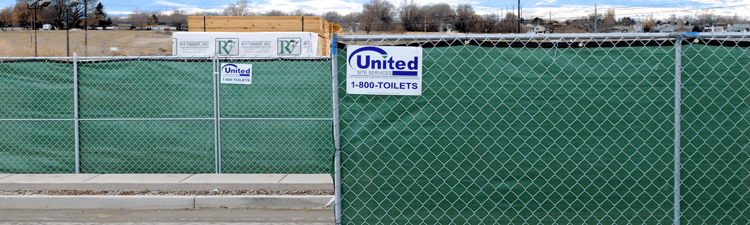 A green chain link fence with a united sign on it.