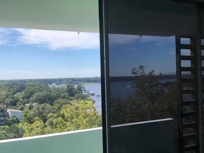 A balcony with a view of a body of water and trees