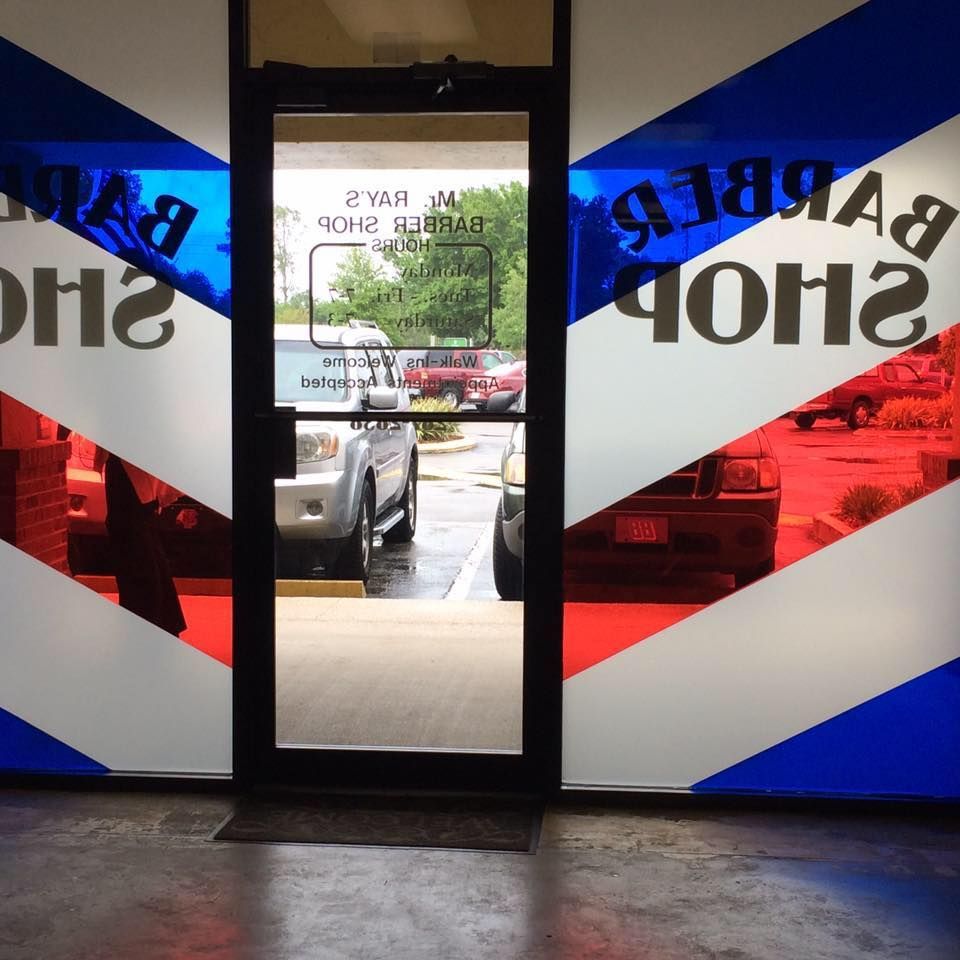 A barber shop with a red white and blue sign