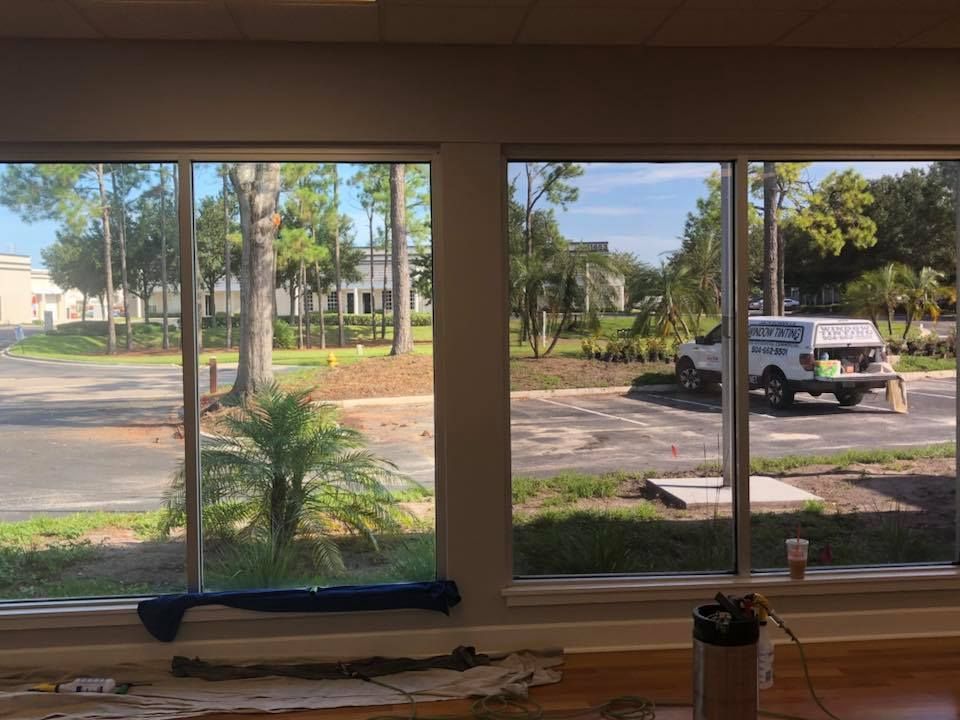 A room with two windows and a truck parked in the background.