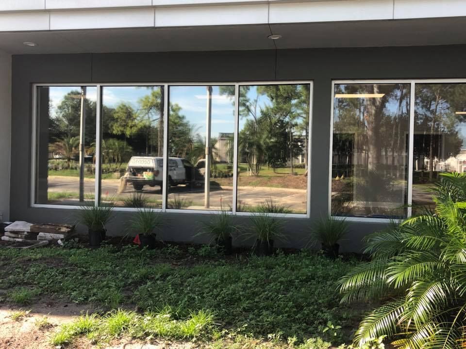 A car is reflected in the windows of a building.