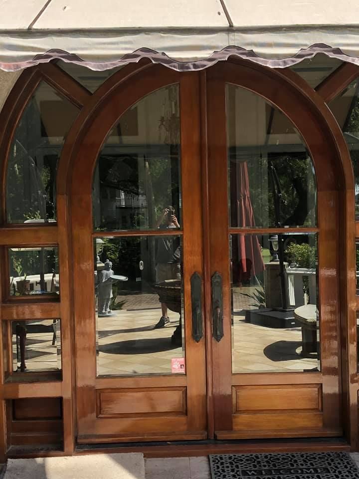 A pair of arched wooden doors leading to a patio.