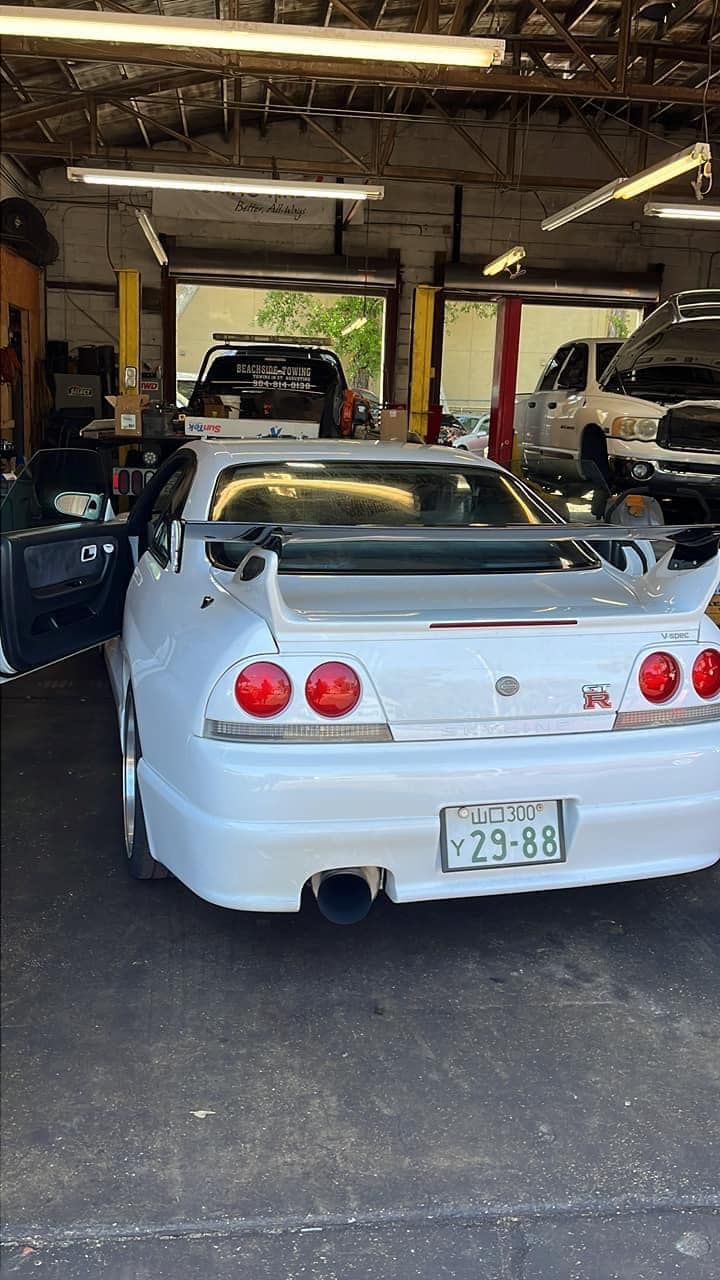 A white sports car is parked in a garage.