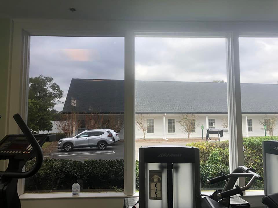 A gym with a view of a car parked in front of a building