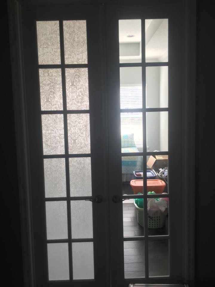 A french door is open to a room filled with boxes and baskets.