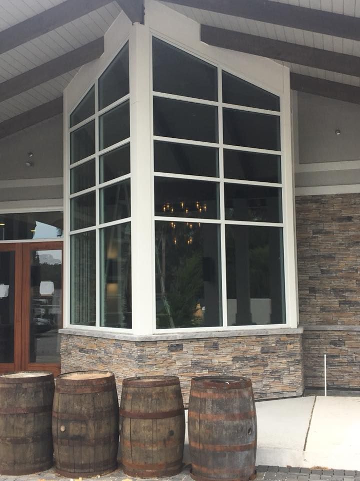 A building with a large window and barrels in front of it