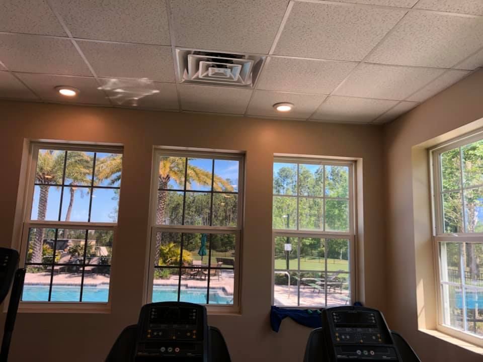 A gym with treadmills and a pool in the background