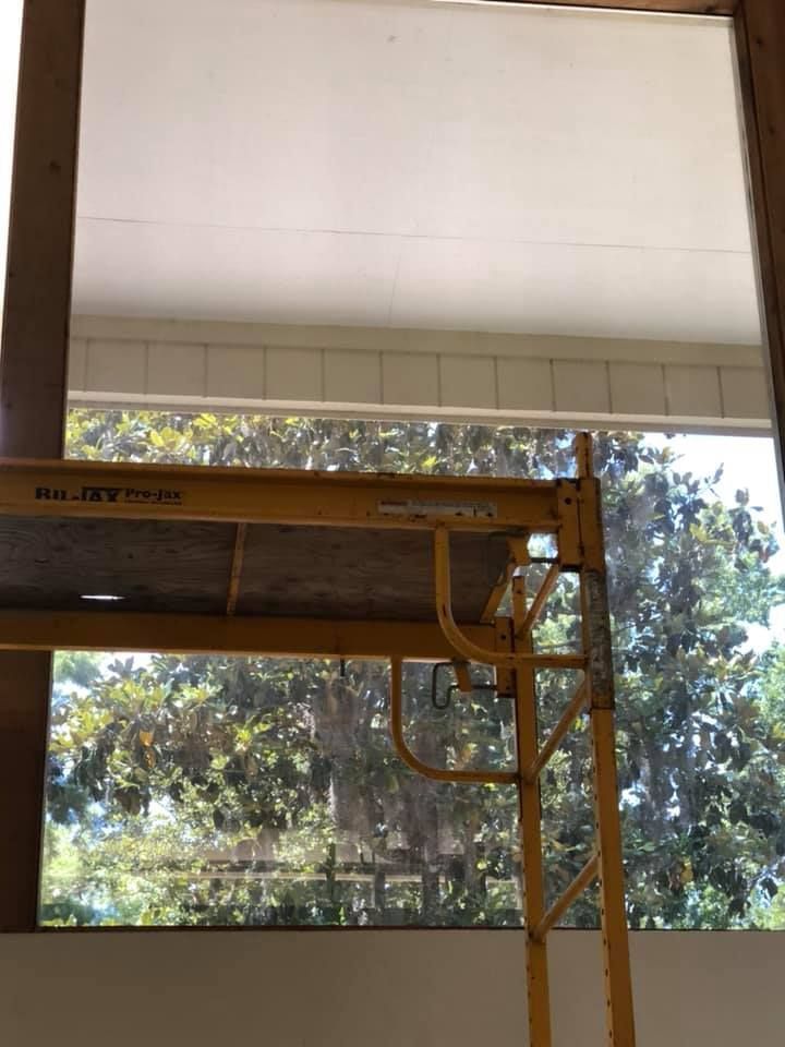 A yellow scaffolding is sitting in front of a window.