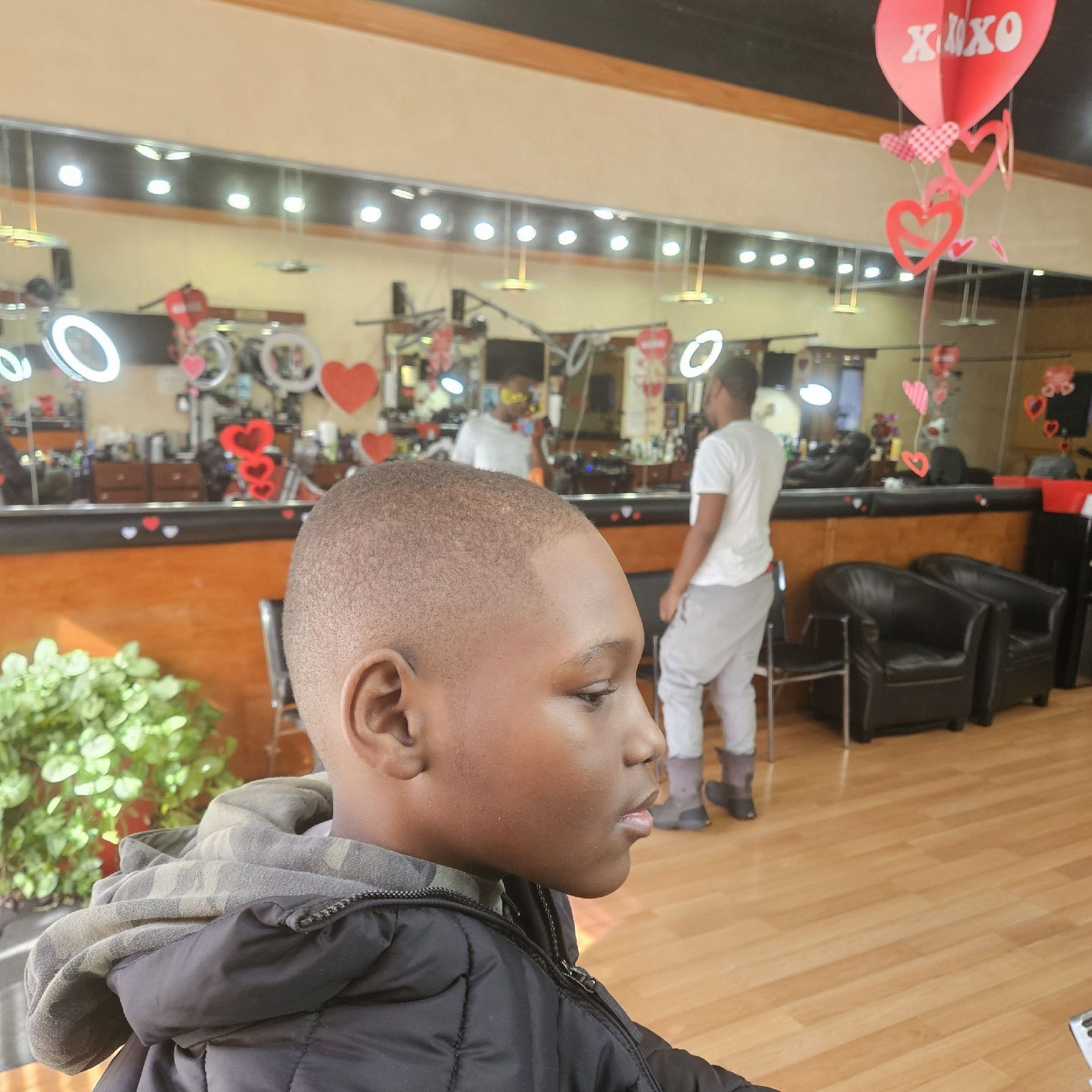Boy with a fresh haircut at a barbershop. Valentine's Day decorations.