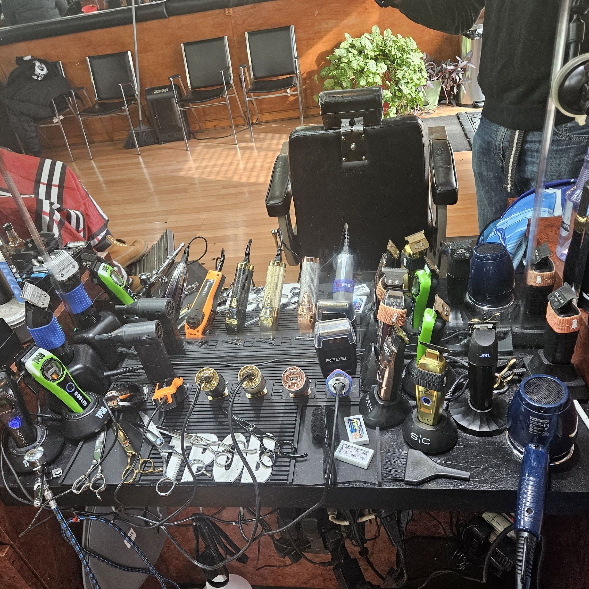 A barber's workstation with various tools like clippers and trimmers. The setting appears to be a barbershop.