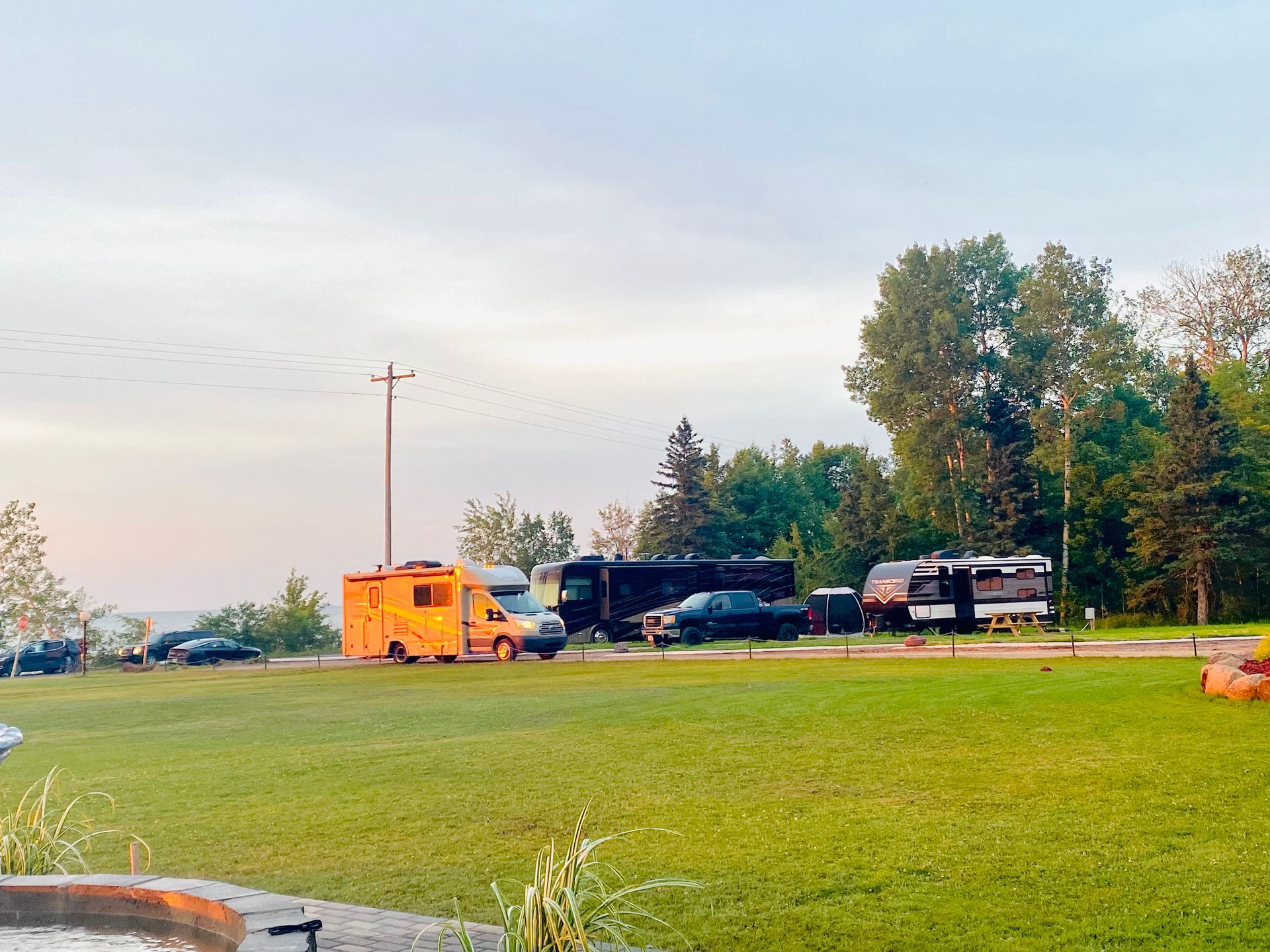 A group of rvs are parked in a grassy field.