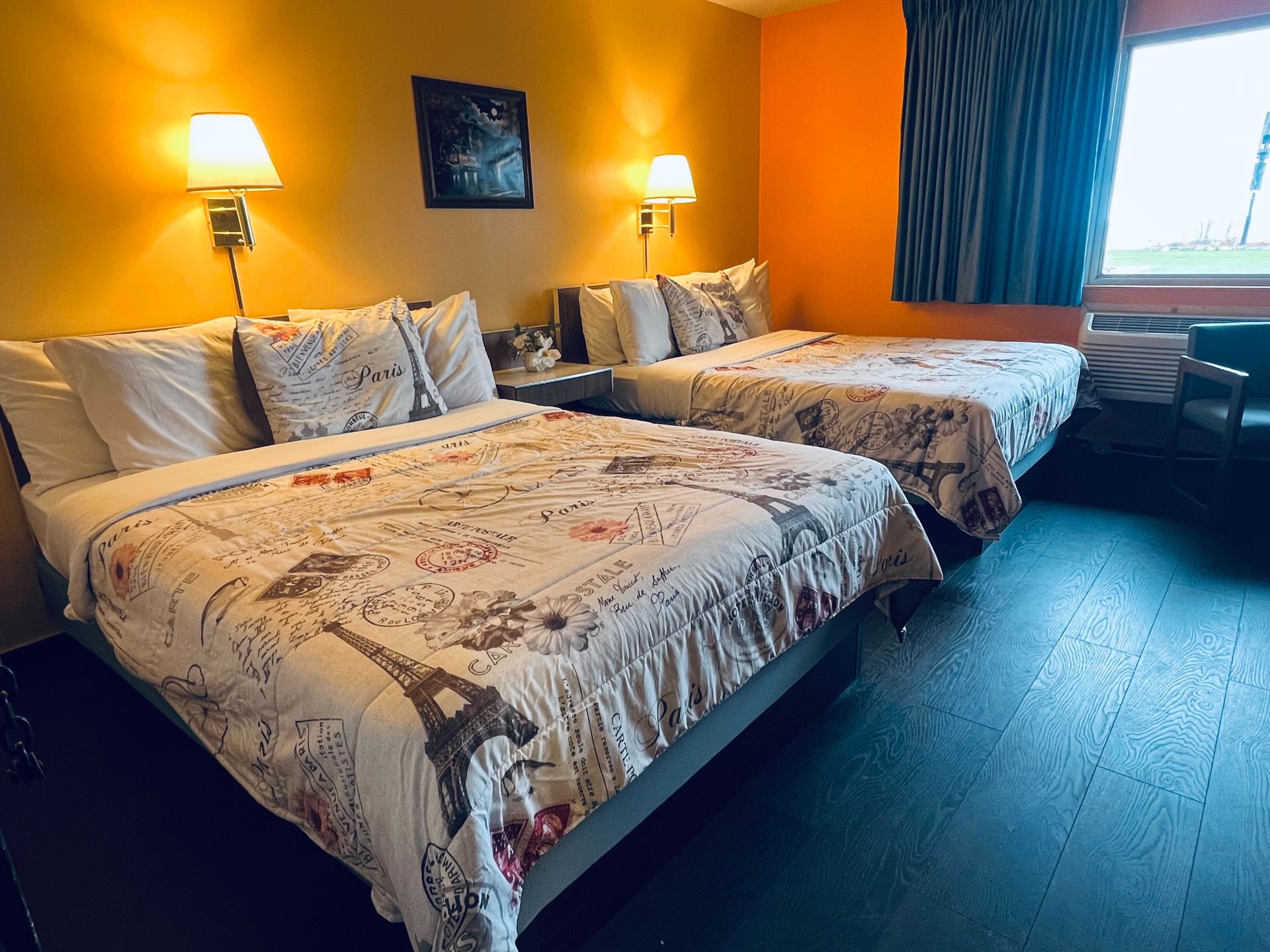 A hotel room with two beds and a large window.