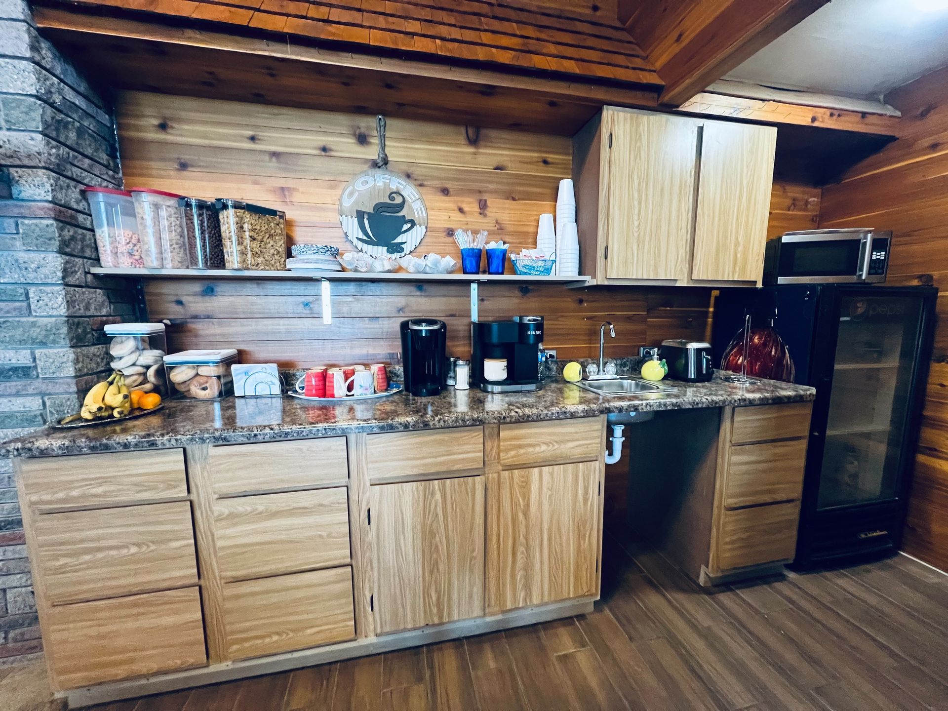 A kitchen with wooden cabinets , granite counter tops , and a refrigerator.