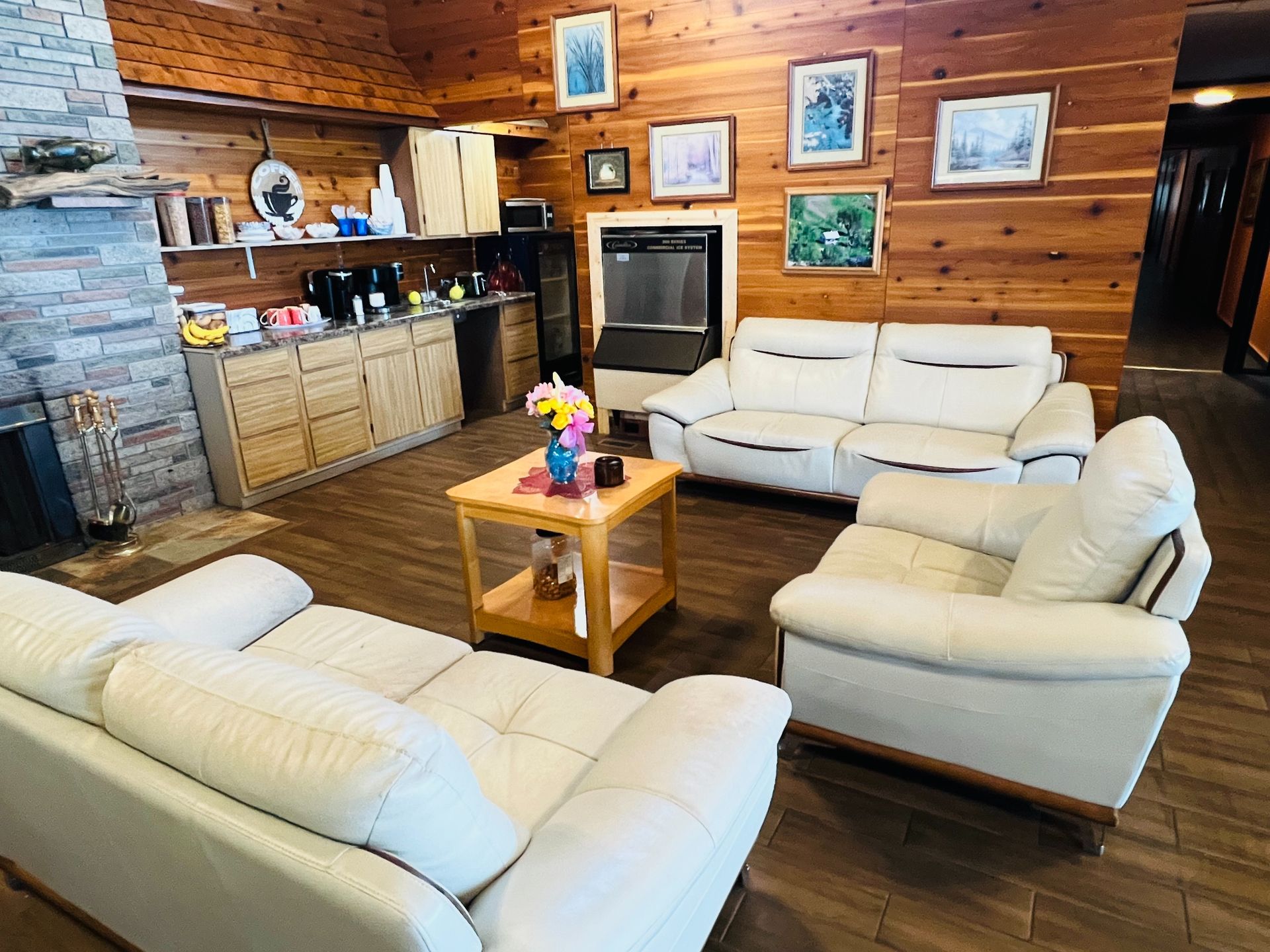 A living room with a couch , chair , coffee table and fireplace.