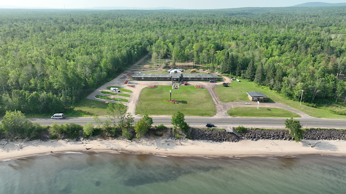 An aerial view of a large body of water surrounded by trees and a road.