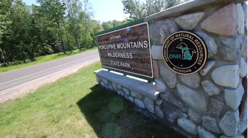 A stone wall with a sign that says ' porcupine mountains wilderness ' on it