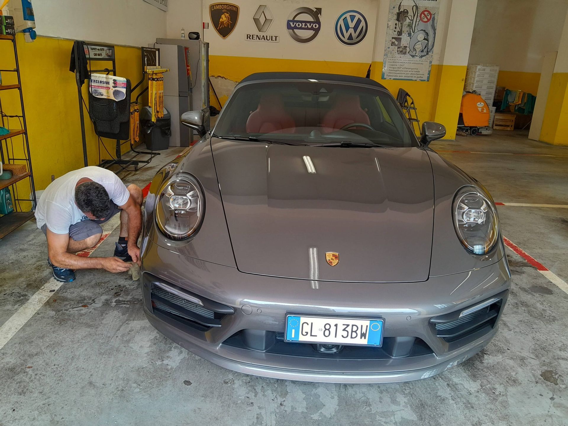 Un uomo sta lavorando su una porsche in un garage