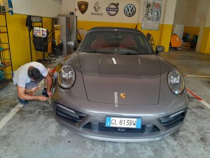 Un uomo sta lavorando su una porsche in un garage