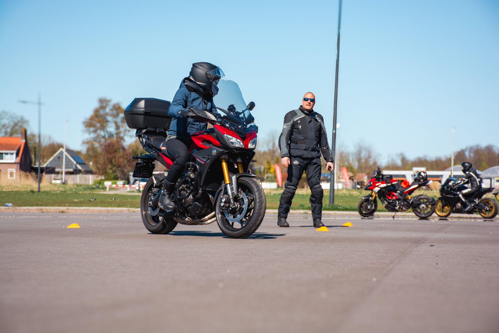 Een man leert een andere man hoe hij op een motorfiets moet rijden op de weg.