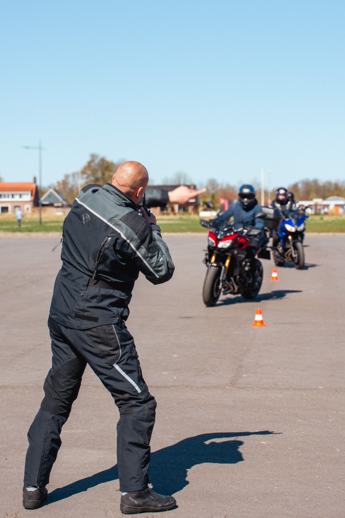 Een man maakt een foto van een groep mensen die op een motorfiets rijden.