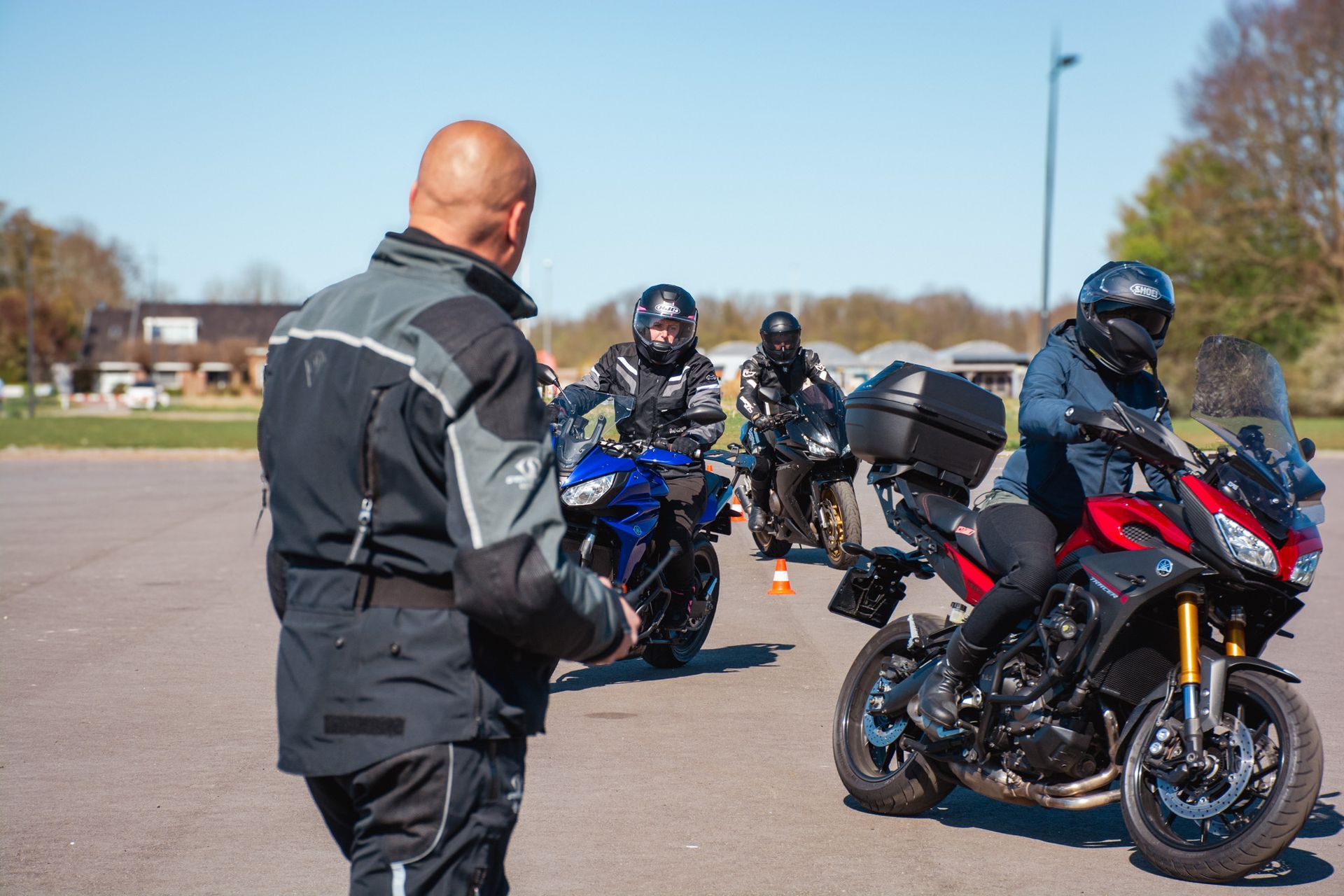 Een man staat naast een groep motorrijders.
