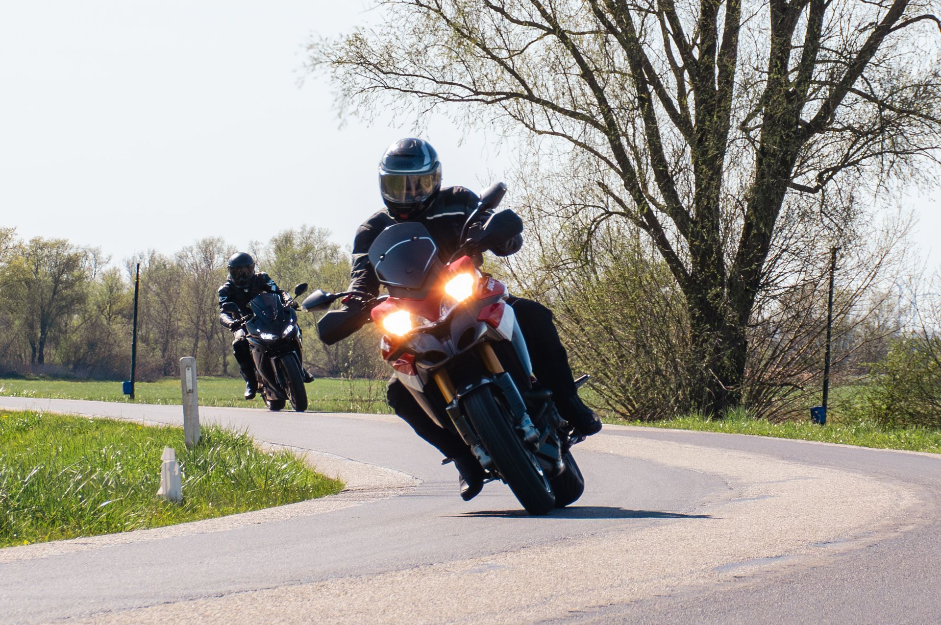 Een man rijdt op een motorfiets over een landweg.